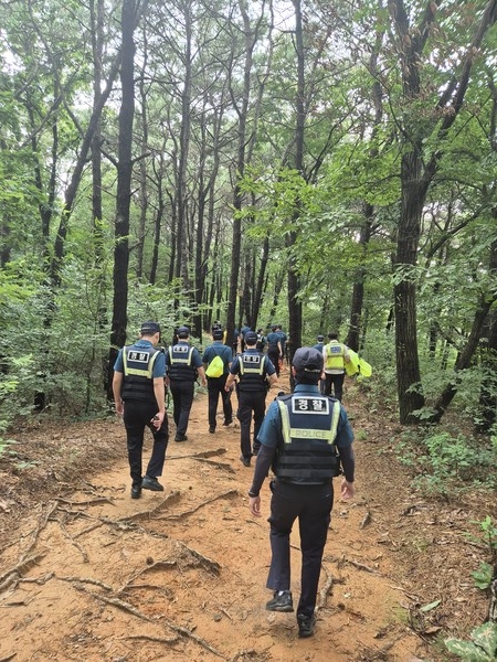 무더운 날씨에도 불구하고 인근 야산의 산책로를 순찰하고 있다.[사진=파주경찰서]