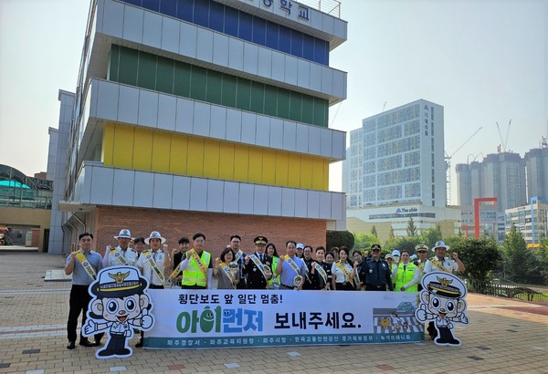 문구는 명확하게 전달되고 있지만, 조금 더 매끄럽게 수정할 수 있습니다. 다음과 같이 수정해볼 수 있습니다:“파주경찰서 직원들과 관계기관들이 ‘아이먼저’라는 슬로건을 내걸고 지산초등학교 앞에서 교통안전 캠페인을 실시한 후 기념촬영을 하고 있다. [사진=파주경찰서]”